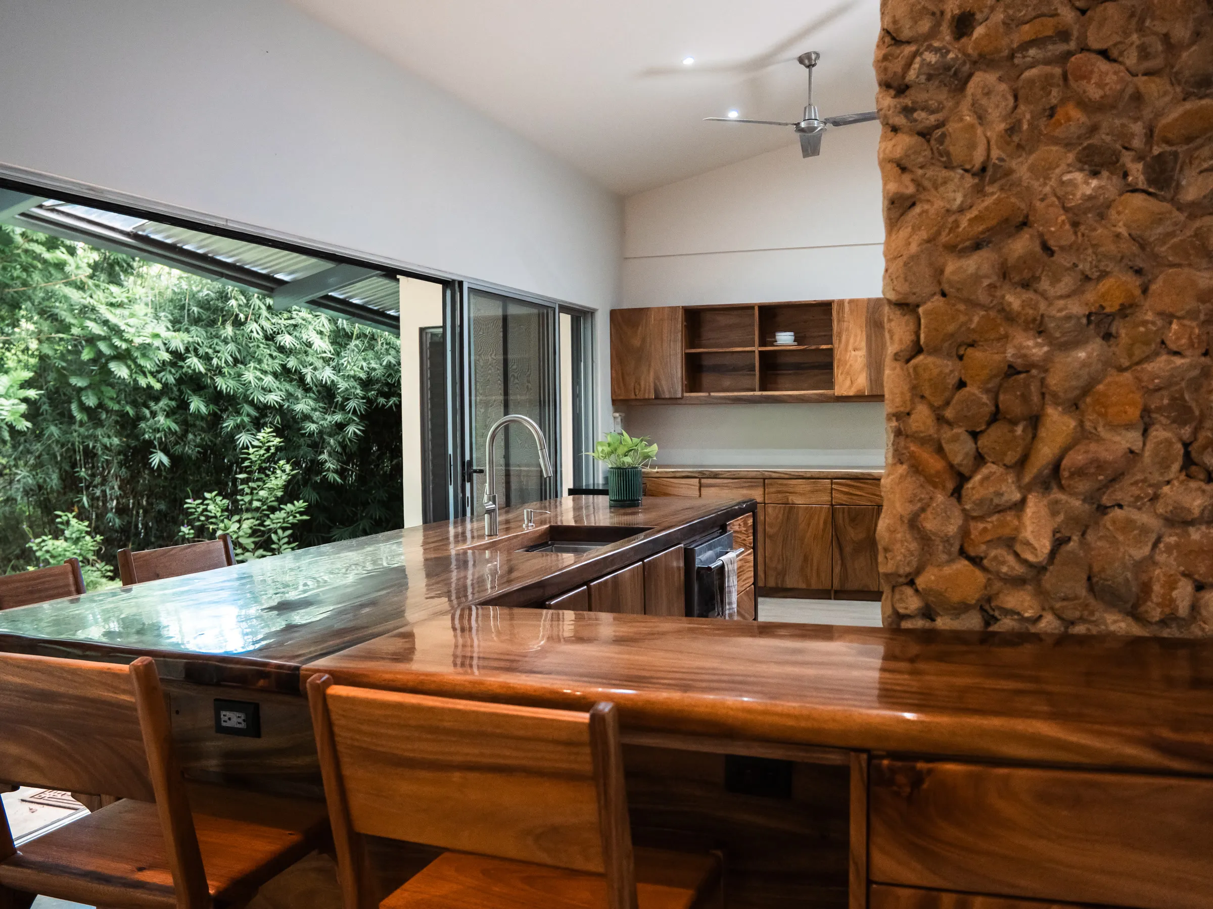 Cocina abierta al jardín con barra en L de Guanacaste macizo